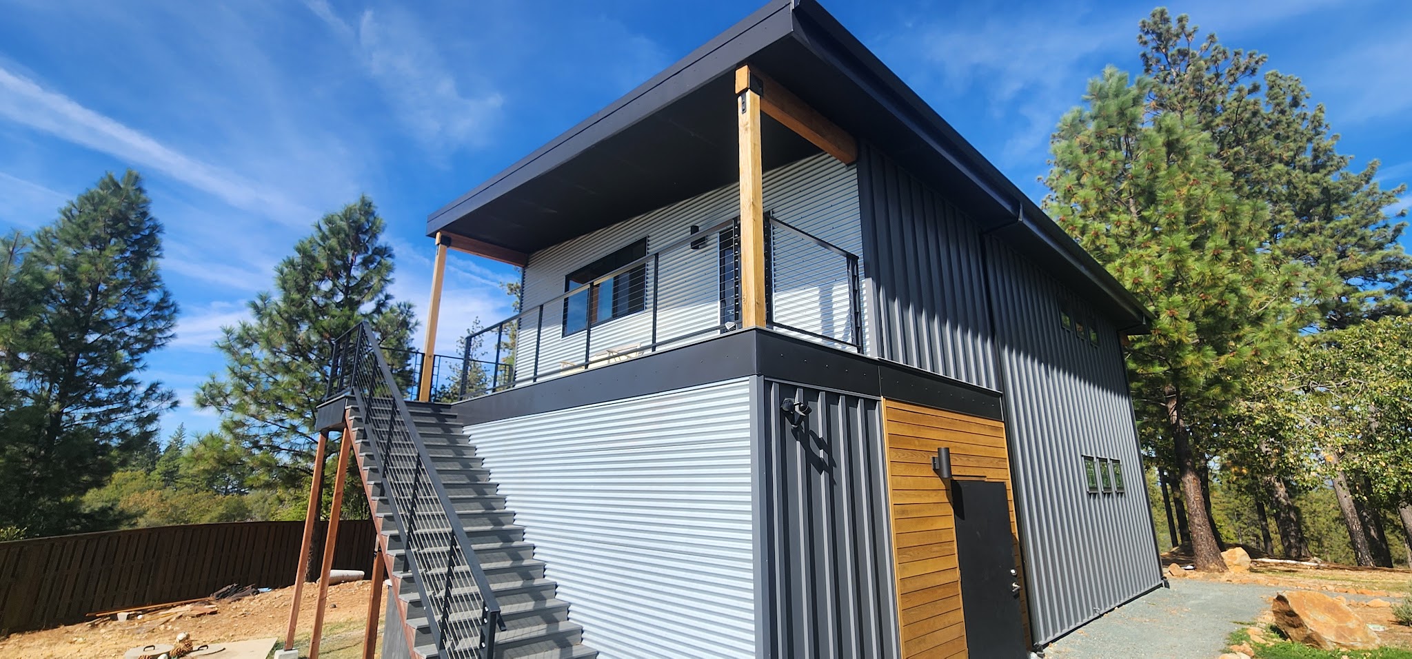 Modern building exterior with metal siding and a wood-accent door