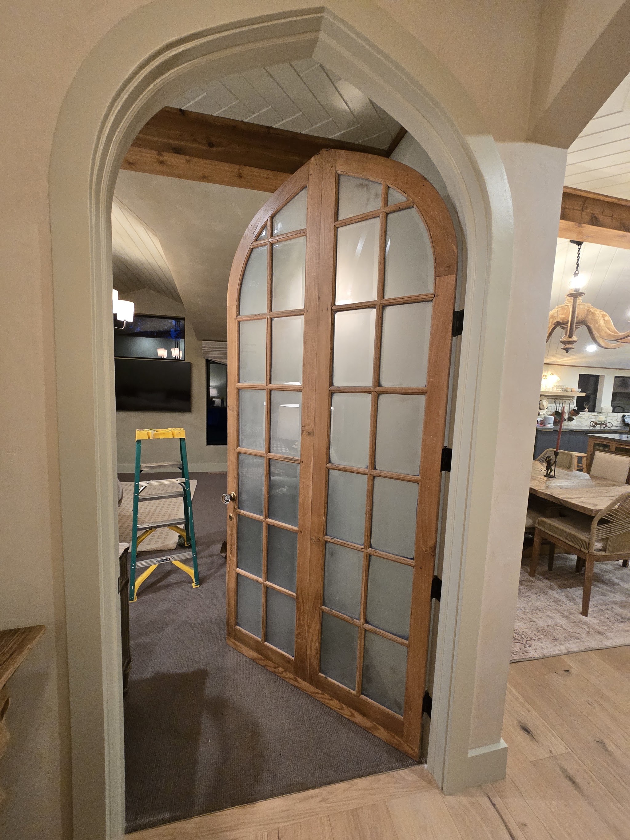 Arched wood-framed glass door with a natural stained finish