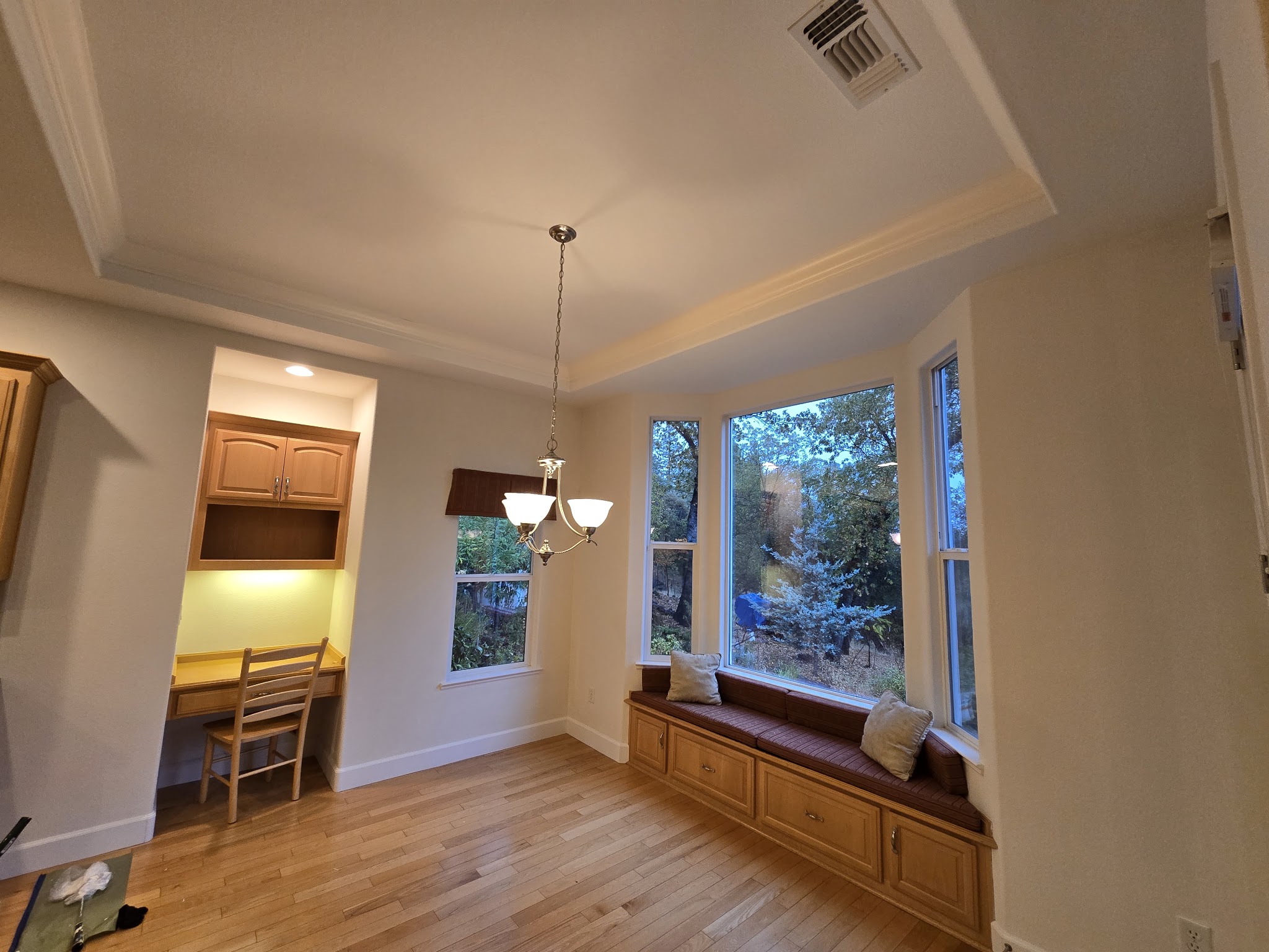 Bay window nook with freshly painted white trim and crown molding